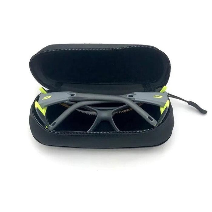 A pair of gray and yellow sports sunglasses is stored in an open Julbo Eyewear Collapsible Travel Sunglasses Case.