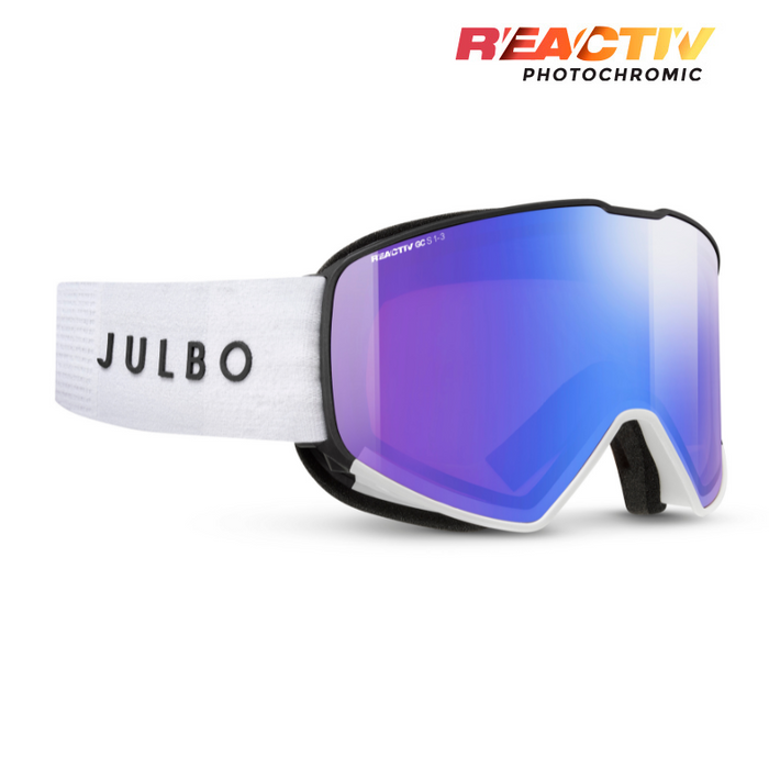 Julbo snow goggles with a white textured strap, black frame, and a blue-to-purple mirrored lens. The JULBO brand name is printed on the strap, and the REACTIV PHOTOCHROMIC logo is visible in the top right corner.  #color_white-black-with-reactiv-1-3-glare-control-lens