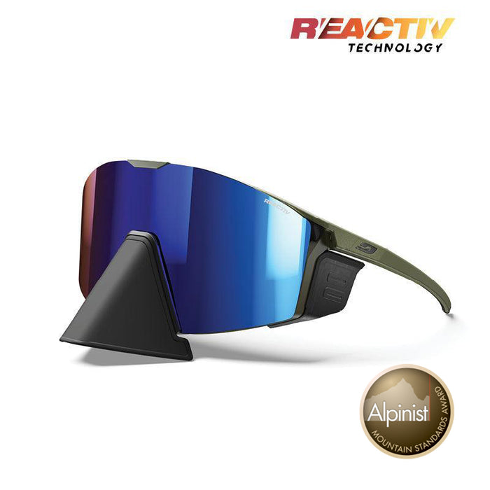 Julbo Eyewear Edge Cover sunglasses feature blue mirrored lenses, an olive green frame, Reactiv Technology branding, and an adjustable nosepiece. Includes a display stand and Alpinist Mountain Standards Award badge. #color_army-black-with-reactiv-2-4-lens