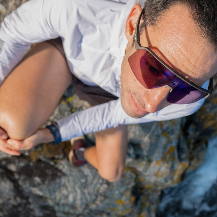 Person wearing sunglasses and a white shirt outdoors