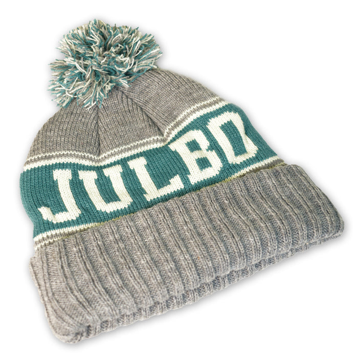The Julbo Eyewear Classic Pom Beanie is a gray winter hat with green and white stripes, a pom-pom, and "JULBO" knitted on the front—perfect for staying warm in Alpine style. #color_julbo-classic-pom-beanie-grey-green-and-lime