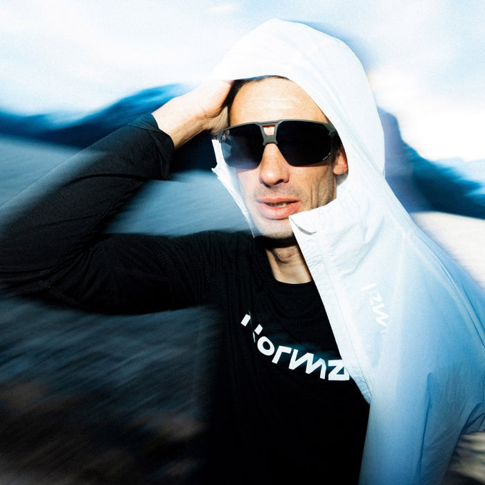 Person wearing sunglasses and a black hoodie with 'horizon' text on a blue and white background