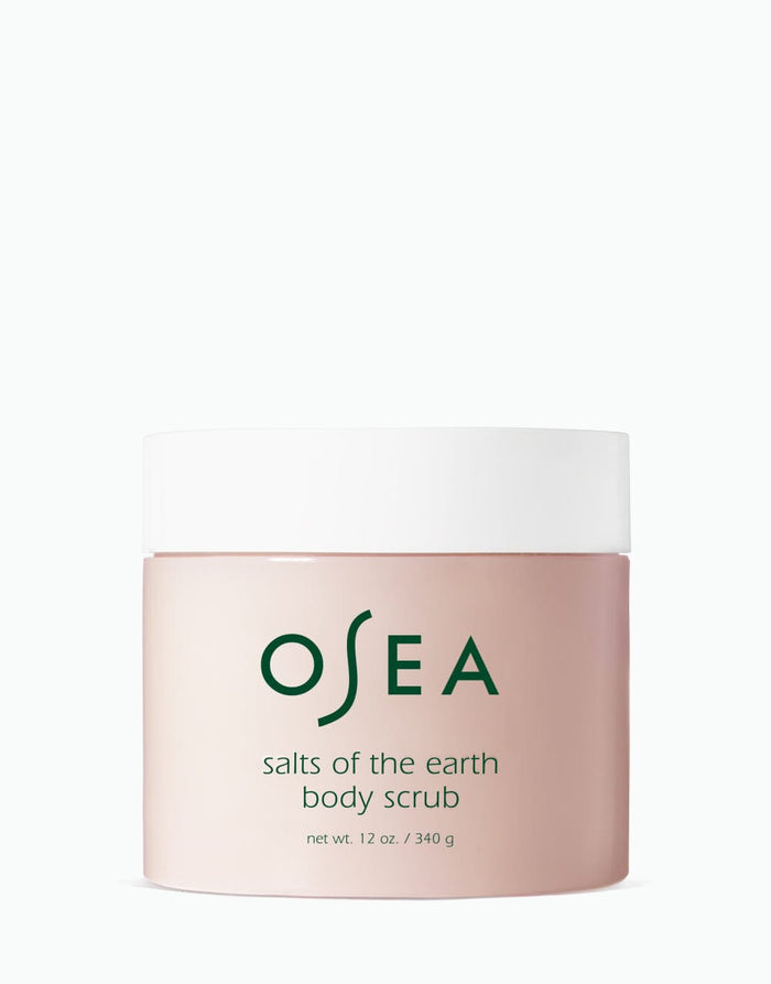 A container of OSEA salts of the earth body scrub with minimalistic design in a pink hue.