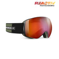 Julbo snow goggles with a red-to-orange reflective photochromic lens and a black and olive green strap, shown on a white background with a 'REACTIV PHOTOCHROMIC' badge in the top right. #color_green-black-with-reactiv-0-4-high-contrast-lens