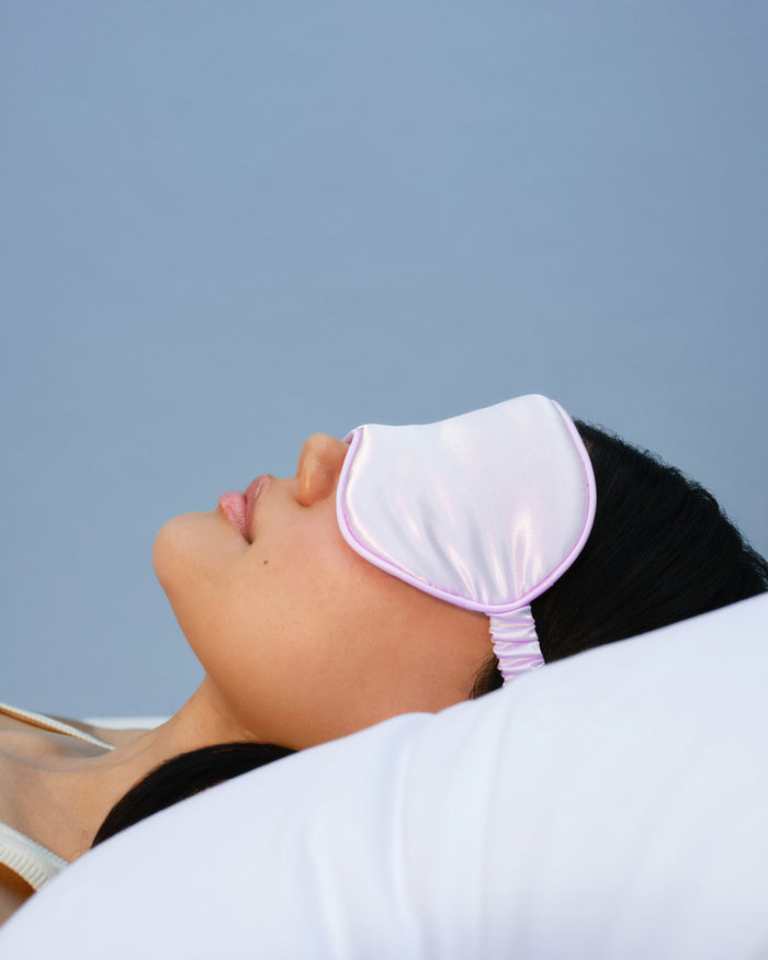 Lavender satin sleep mask worn during rest to promote uninterrupted beauty sleep