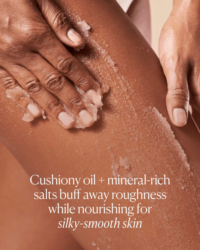 Person scrubbing their skin with a cushiony oil and mineral-rich salt product.