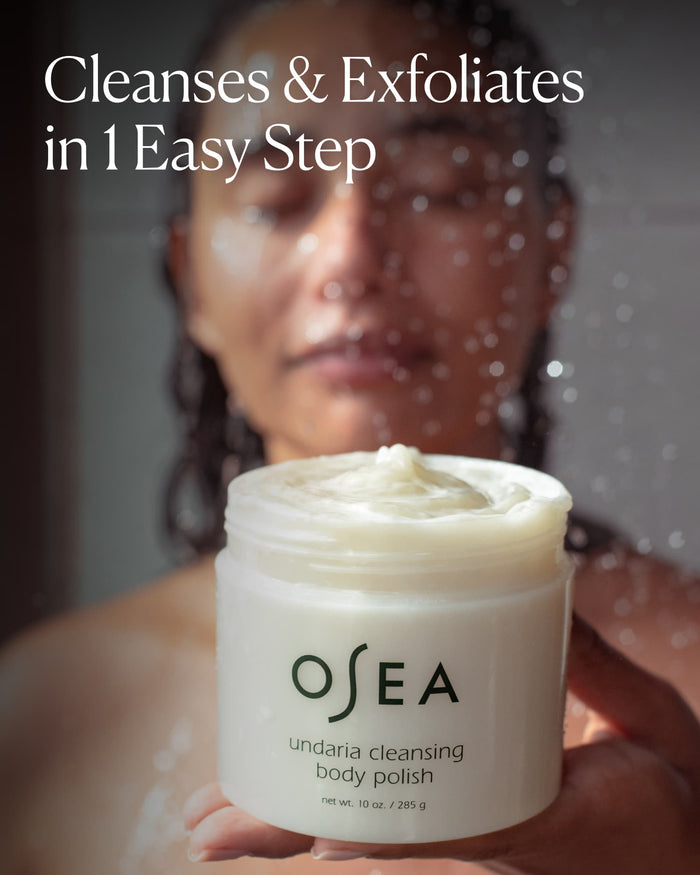 Woman holding Undaria Cleansing Body Polish in shower with text “Cleanses & Exfoliates in 1 Easy Step”