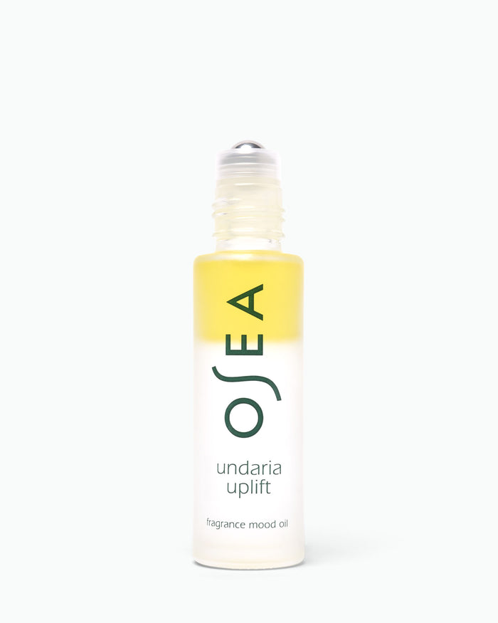 A bottle of OSEA Undaria Uplift fragrance mood oil with a yellow-to-clear gradient label and a clear rollerball cap, centered on a white background.